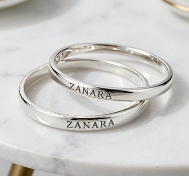 Set of silver bracelets with clean lines and a matte finish, arranged on a black velvet cloth.