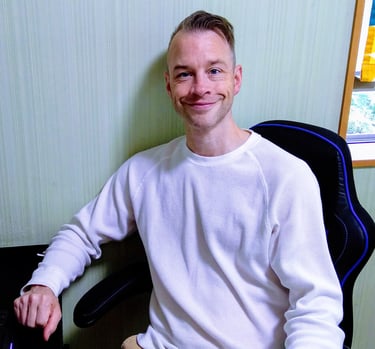 an online English teacher sitting at a computer desk