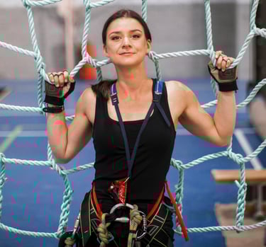 a woman in a black top and climbing harness