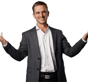 Remy ,wearing a gray blazer over a white button-up, holds his arms wide with a big smile on his face