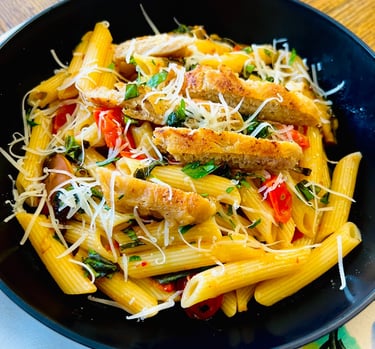 A savory plant-based patty slice, pan-seared to perfection, blends beautifully with al dente pasta,