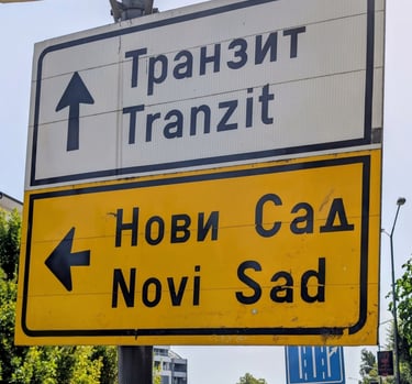 Serbian road sign pointing towards Novi Sad and Tranzit transit routes in Cyrillic and Latin script.