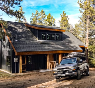 Modern detached garage with dark siding and wood trim built by Elk Valley Contractors in Evergreen, Colorado.