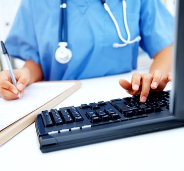 Nurse typing documentation on the keyboard..
