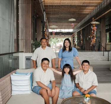 family photography session indoors at Movenpick Jimbaran Bali with parents and children sitting together in a relaxed setting