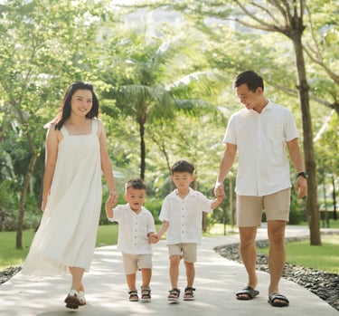 Parents walking with their children through tropical garden pathways at The Apurva Kempinski Nusa Dua Bali