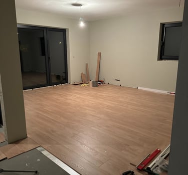 a room with a large wooden floor and a television