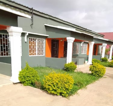 An inviting view of the Kakuba Garden Hotel, surrounded by lush greenery and colorful flowers. The h