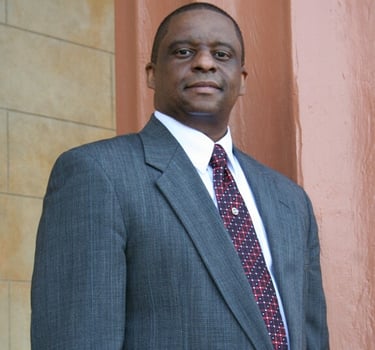 Mark T. Stewart in a suit and tie standing in front of the Old Courthouse