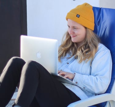 a woman sitting in a chair with a laptop on her lap