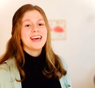 ein Mädchen singt freudig in einem hellen Raum