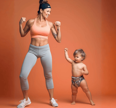 a woman in a sports brailler and a baby in a diaper