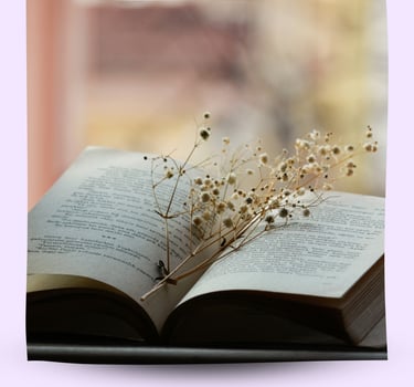 An open book with dried flowers in the middle.