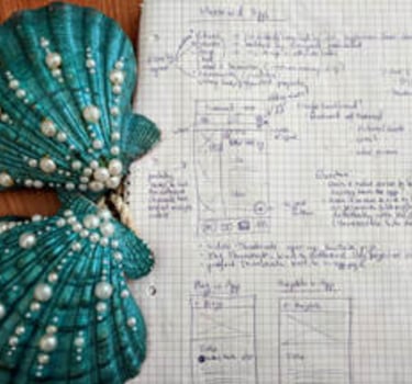 paper wireframes with a beautiful mermaid bra next to it