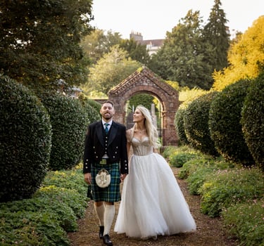 a bride and groom walking through a garden
