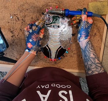 a person who is soldering a sun catcher, stainglass