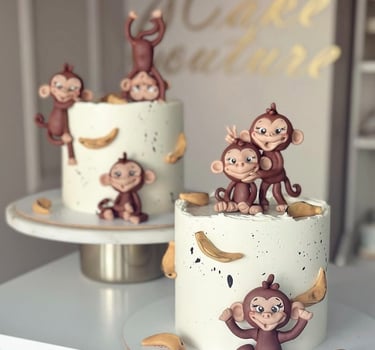a cake with three monkeys on top of a table