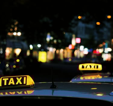 Taxi sign on a black roof of a vehicle