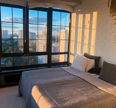 hotel bedroom with a bed and a large window. Digital Nomad Accommodation with Timea Pokol Consultant