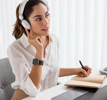 Pharmacovigilance training – woman with headset taking notes during an online training session on PV