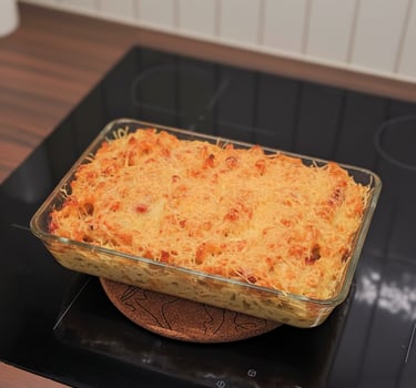 Gratin de macaronis dorés à l'emmental et lardons, nappe de sauce onctueuse au comté dans un plat