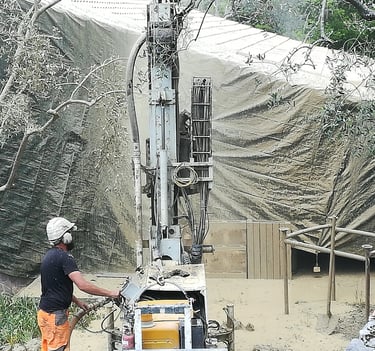 On y voit un technicien, Foreuse en pleine action pour un forage de qualité sur terrain difficile.