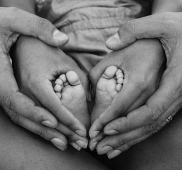 Parents holding babies feet in a heart shape