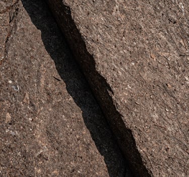 Abstract macro photography of rock textures in a Canadian national park. High contrast shadows, warm taupe and deep brown tones, sharp focus on natural patterns in a minimalist Japandi composition.