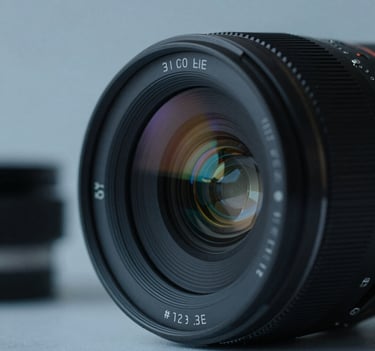 Close-up of a high-end cinema lens with subtle blue reflections (#2C3E50), minimalist background with soft shadows, professional cinematic lighting.