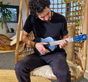 a man sitting on a swing chair with a guitar