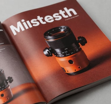 A high-end print advertisement spread in a glossy magazine, showcasing professional typography and a striking product image in a modern North American setting with reddish orange accents.