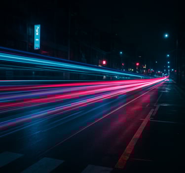 Abstract motion blur photography of urban traffic lights at night, long exposure, streaks of electric cyan and magenta light cutting through dark charcoal streets, East Asian / Korean urban.