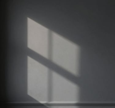 Abstract play of light and shadow on a matte dark grey wall, minimalist composition, soft professional lighting, elegant architectural detail, European / Spanish style.