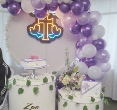 Decoración de bautizo con globos morados, pastel y cruz luminosa para Zoe.