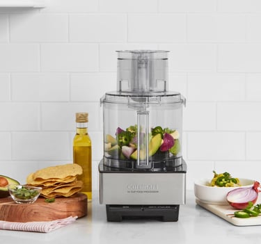 Cuisinart 14-cup food processor on a kitchen counter with fresh salsa ingredients and tortilla chips.