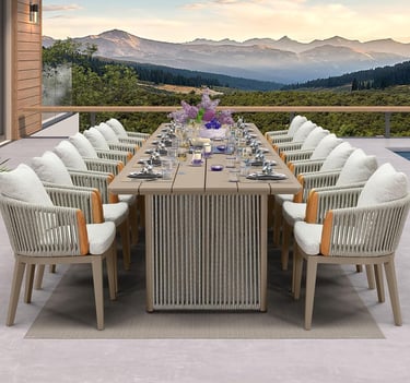 Luxury outdoor dining set with a long table and woven armchairs on a patio with mountain views.