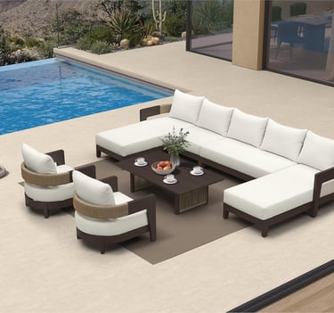 Luxury outdoor patio furniture set with white sectional sofa and armchairs by a blue swimming pool.
