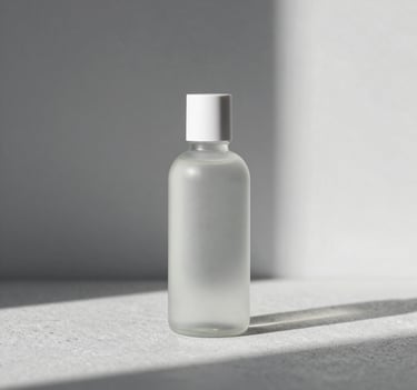 Minimalist high-end creative product photography. A sleek glass bottle on a light gray stone surface. Architectural shadows, natural soft lighting. Palette of #F8F5F2 and #D8D8D8.