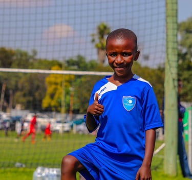 a young boy is playing soccer on a soccer field