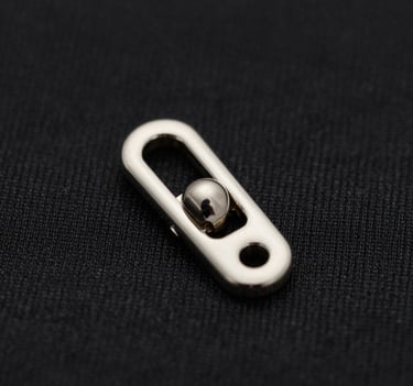Artistic macro shot of a minimalist silver garment fastening on a textured black fabric, sharp focus, sophisticated lighting, #0F0F0F and #D0D0D0 palette.