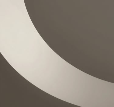 Architectural model detail. A study of shadows cast on a white curved surface using light and shadow. Minimalist, clean, high-end photography in Charcoal and Soft Sand tones.