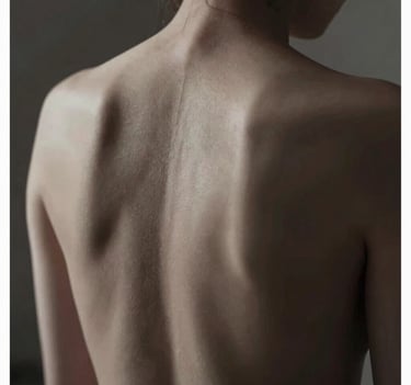 A chiaroscuro photograph focusing on the artistic expression of a human back, soft light tracing the spine, deep shadows in #1F1E1C, skin tones in #F5F2EF, refined and intimate composition.