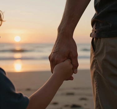 Close-up cinematic shot of a parent's hand holding a child's hand against a backdrop of a North American / US beach at sunset. Warm golden light and deep charcoal shadows create a heartfelt mood.
