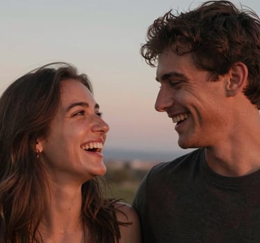 Intimate, candid portrait of a couple sharing a quiet laugh. Soft sunset light casting warm terracotta hues on their faces, shallow depth of field, natural and spontaneous, Spain / Southern Europe.