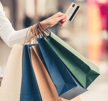 Woman with shopping bags and credit card to symbolise AI in retail
