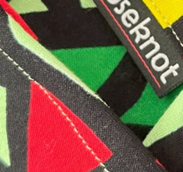 A Noseknot handkerchief showing the Noseknot logo in a suit pocket