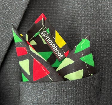 A Noseknot handkerchief showing the Noseknot logo in a suit pocket