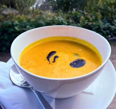 Cremige Kürbissuppe, serviert in einer Schale, dekoriert mit Kürbiskeröl aus der Seeperle in Plön