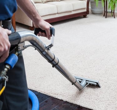a man is cleaning a carpet with an extractor wand