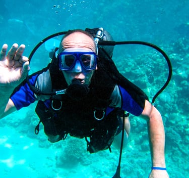 a man in a diving suit and goggles in the water